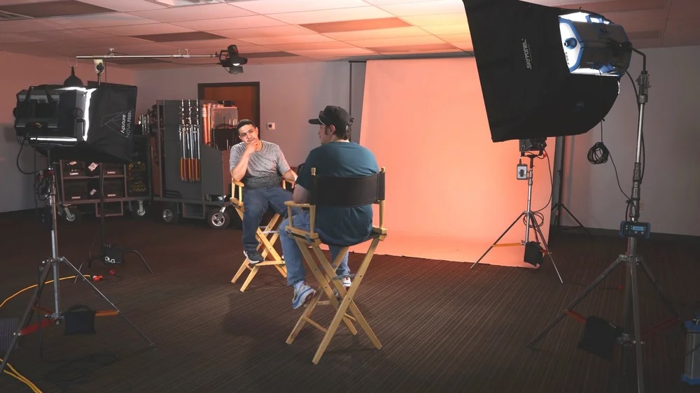 Camera operator filming an interview on set